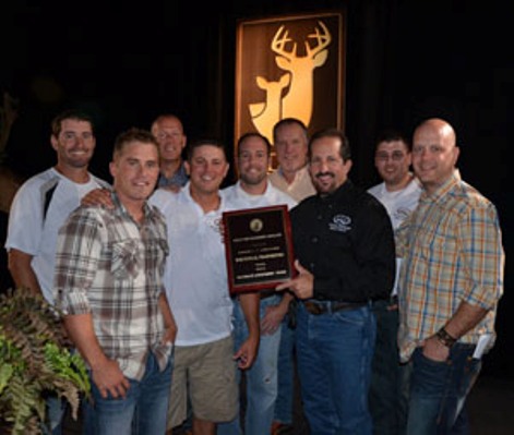 whitetail properties team holding qdma plaque